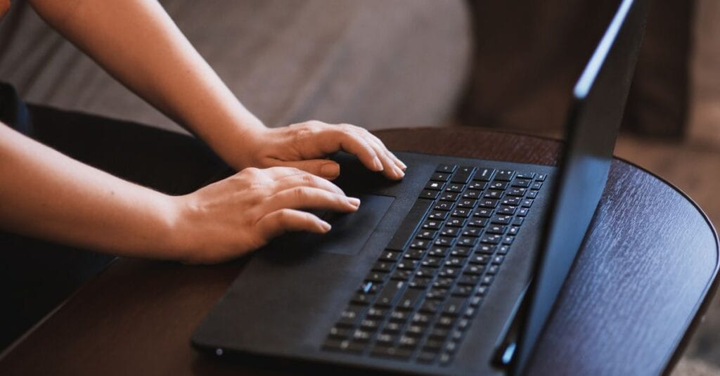 Person typing on a laptop keyboard, representing everyday secure browsing with a VPN | SecureGuides