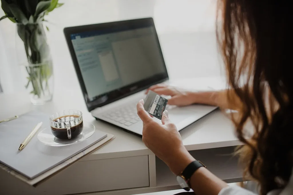 VPN for online banking and shopping safely — woman checking a credit card while using her laptop